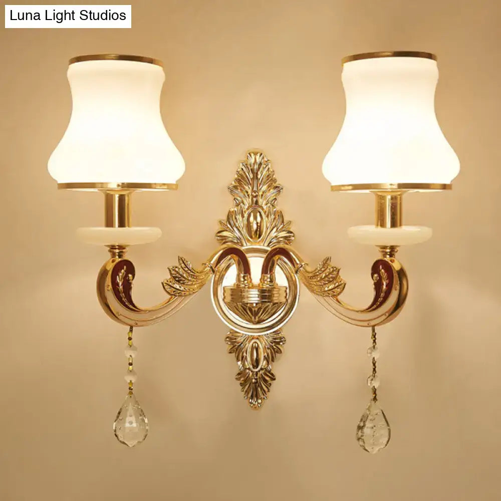 Modernist gold wall sconce with direct wired electric connection features glass shades and crystal teardrop pendants