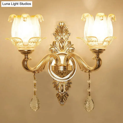 Modernist gold wall sconce with direct wired electric, glass shade, and dangling crystal teardrop pendants