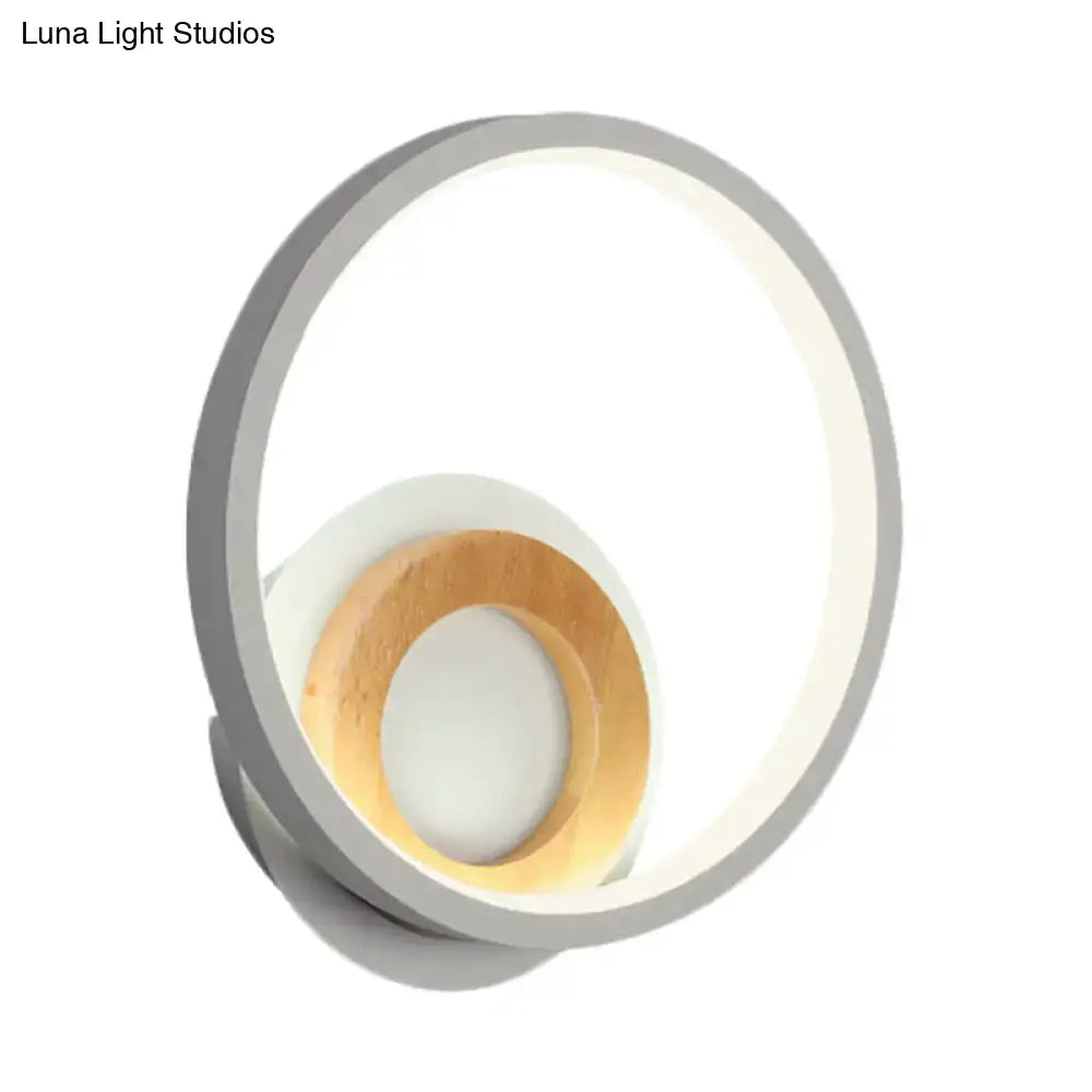 Modernist gray and wood ring wall sconce with sleek circular design and soft diffused LED lighting for bedroom use
