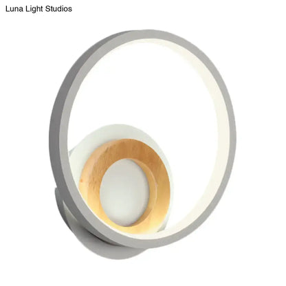 Modernist gray and wood ring wall sconce with sleek circular design and soft diffused LED lighting for bedroom use