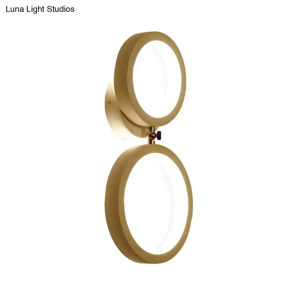 Gold-toned modernist wall lamp with two illuminated circular light fixtures for bedroom corners