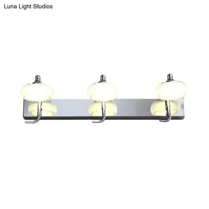 Modernist silver bathroom vanity light with frosted acrylic shades and chrome fixtures including wall lamp and matching hooks