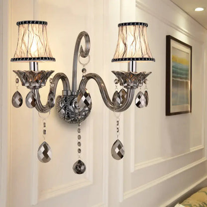 Silver-toned smoke grey crystal chandelier wall sconce with two lampshades and dangling teardrop crystals for living room wall mounted lighting