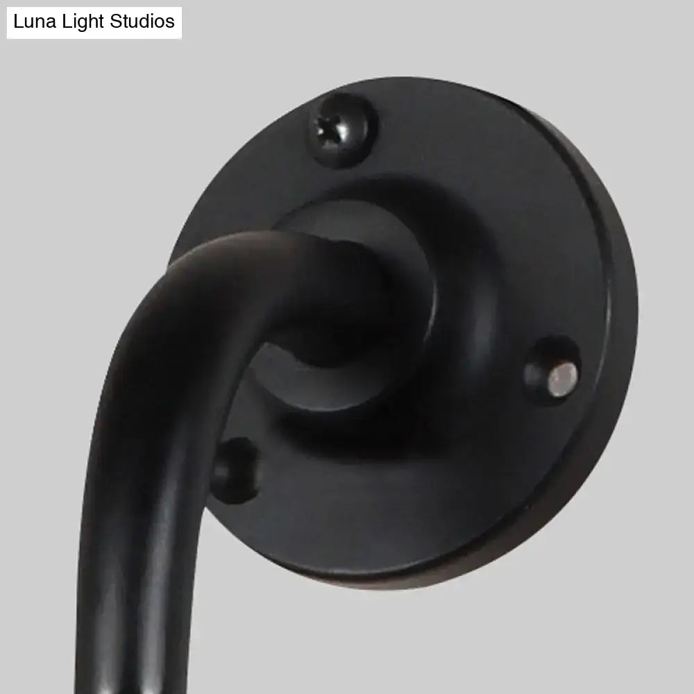 Modernist style black matte metal wall light with curved arm and circular plate for black white dining room decor