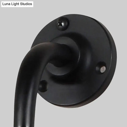 Modernist style black matte metal wall light with curved arm and circular plate for black white dining room decor
