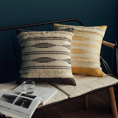 Two textured throw pillows in a moroccan geometric cream and mustard cushion cover set with frayed edges