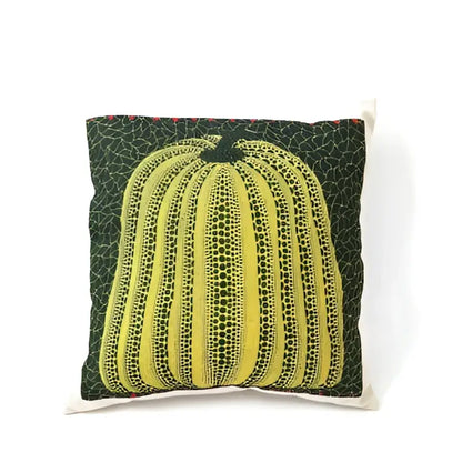 A vibrant yellow decorbites cotton pumpkin pillowcase with dotted texture and black stem on dark green cushion decor