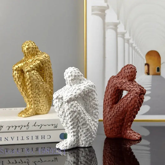 Three abstract golden man thinker statues with mosaic tile texture in gold white and terracotta for living room decor