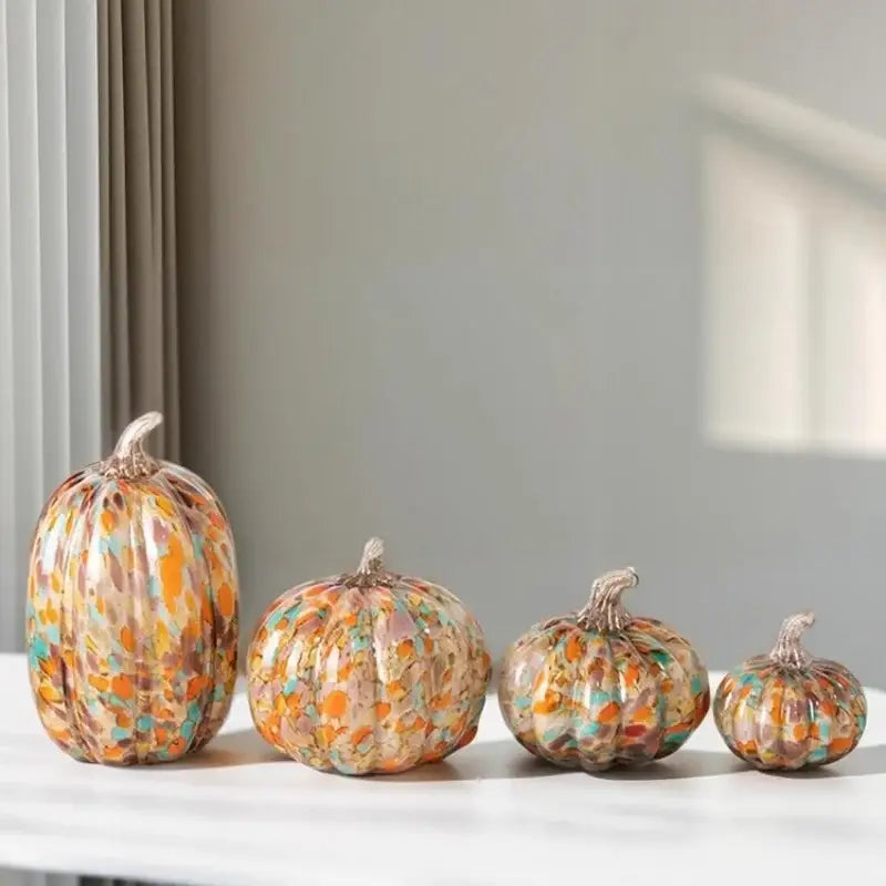 Set of four mosaic orange and teal transparent glazed pumpkin sculptures in warm autumn colors for home decor