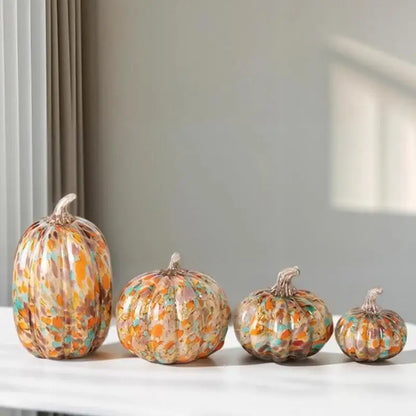 Set of four mosaic orange and teal transparent glazed pumpkin sculptures in warm autumn colors for home decor