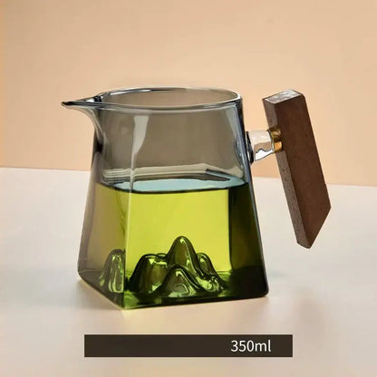 A transparent glass tea cup set with wooden handle and mountain-shaped base filled with green tea for dining room filter