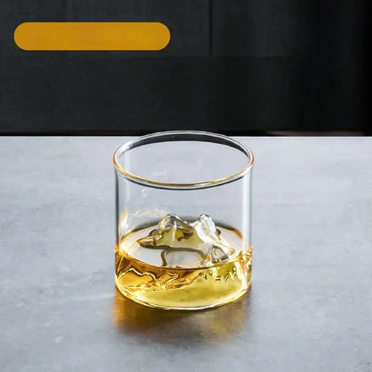 Clear glass tea cup set with gold rim and textured base filled with amber liquid for dining room use