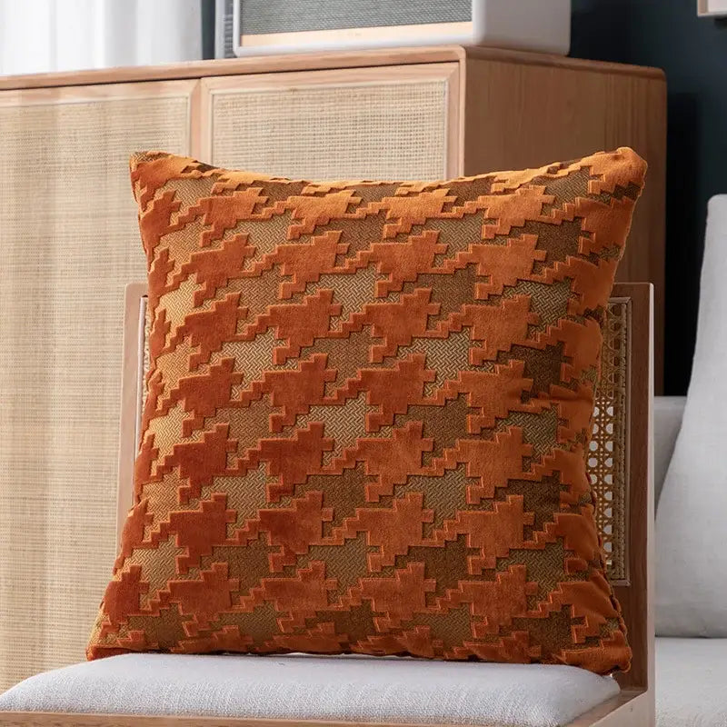 A square plush pillow cover with a bold burnt orange and tan houndstooth luxury pattern for living room decor