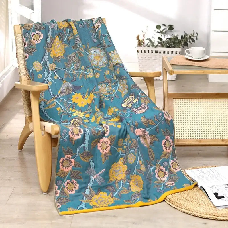 A teal multicolor gauze flower bath towel with yellow and pink blossoms decorbites gauze flower on wooden chair