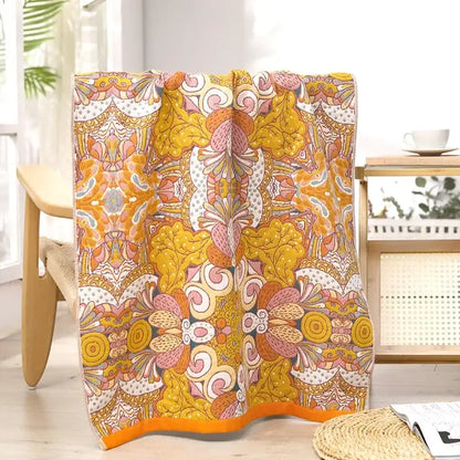 A multicolor decorbites gauze flower bath towel with a vibrant psychedelic floral design in yellow pink and white