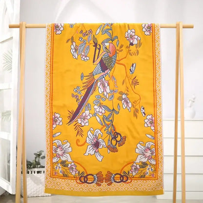 A vibrant yellow silk decorbites gauze flower bath towel featuring a colorful bird and floral design for bedroom decor