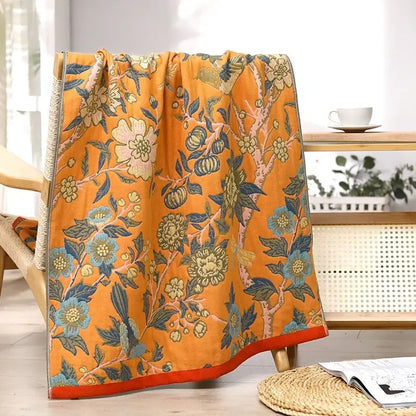 Vibrant orange decorbites gauze flower bath towel featuring intricate blue green and cream floral pattern on textured fabric