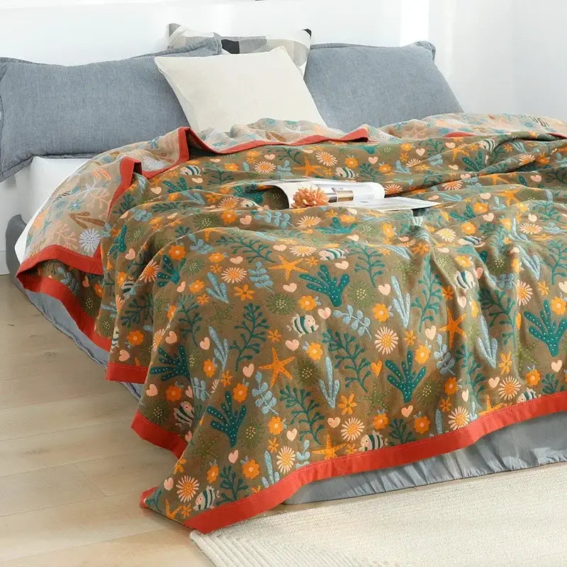 A cozy olive green cotton gauze boho throw blanket with orange flower and teal seaweed pattern for bedroom or living room decorbites cotton gauze