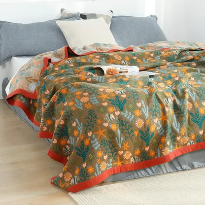 A cozy olive green cotton gauze boho throw blanket with orange flower and teal seaweed pattern for bedroom or living room decorbites cotton gauze