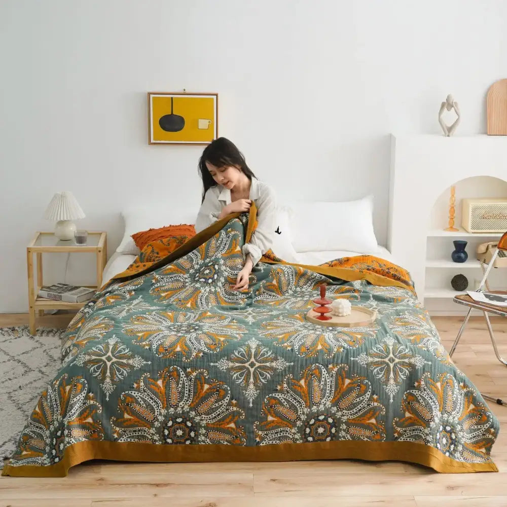 Cozy teal and gold patterned decorbites cotton gauze boho throw blanket with floral designs and warm-toned border