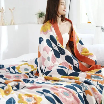 Multicolored cotton gauze boho throw blanket with vibrant pink yellow and navy floral pattern for bedroom or living room decor