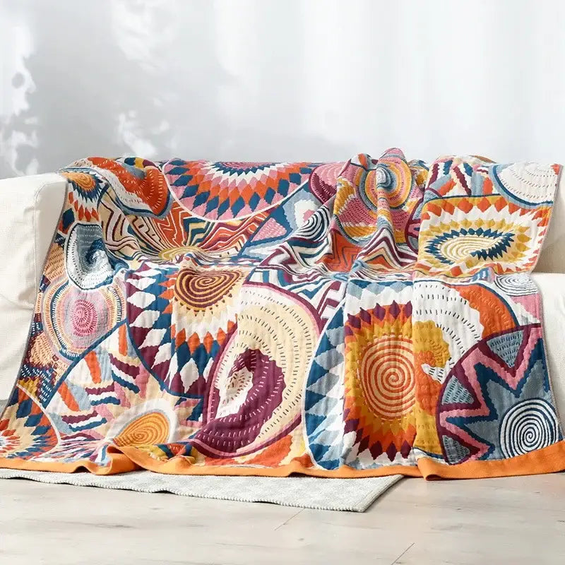 A multicolored cotton gauze boho throw blanket with bold geometric and spiral patterns for bedroom or living room decorbites cotton gauze