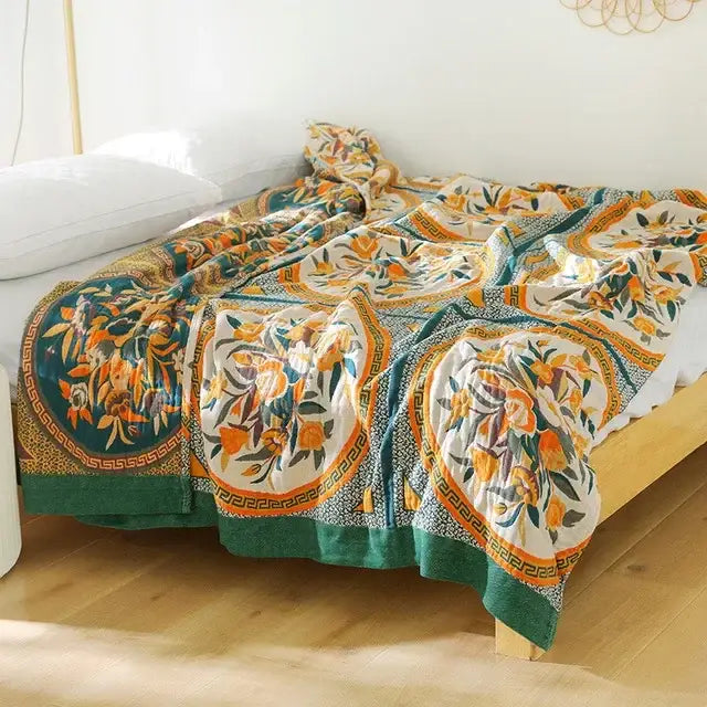 A multicolored cotton gauze boho throw blanket with vibrant orange green floral motifs and geometric borders for decorbites