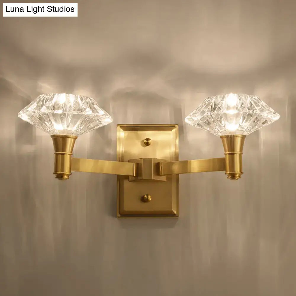 Brass-finished wall mounted lamp with two faceted crystal shades suitable as a bedroom or doorway wall lamp