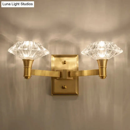 Brass-finished wall mounted lamp with two faceted crystal shades suitable as a bedroom or doorway wall lamp