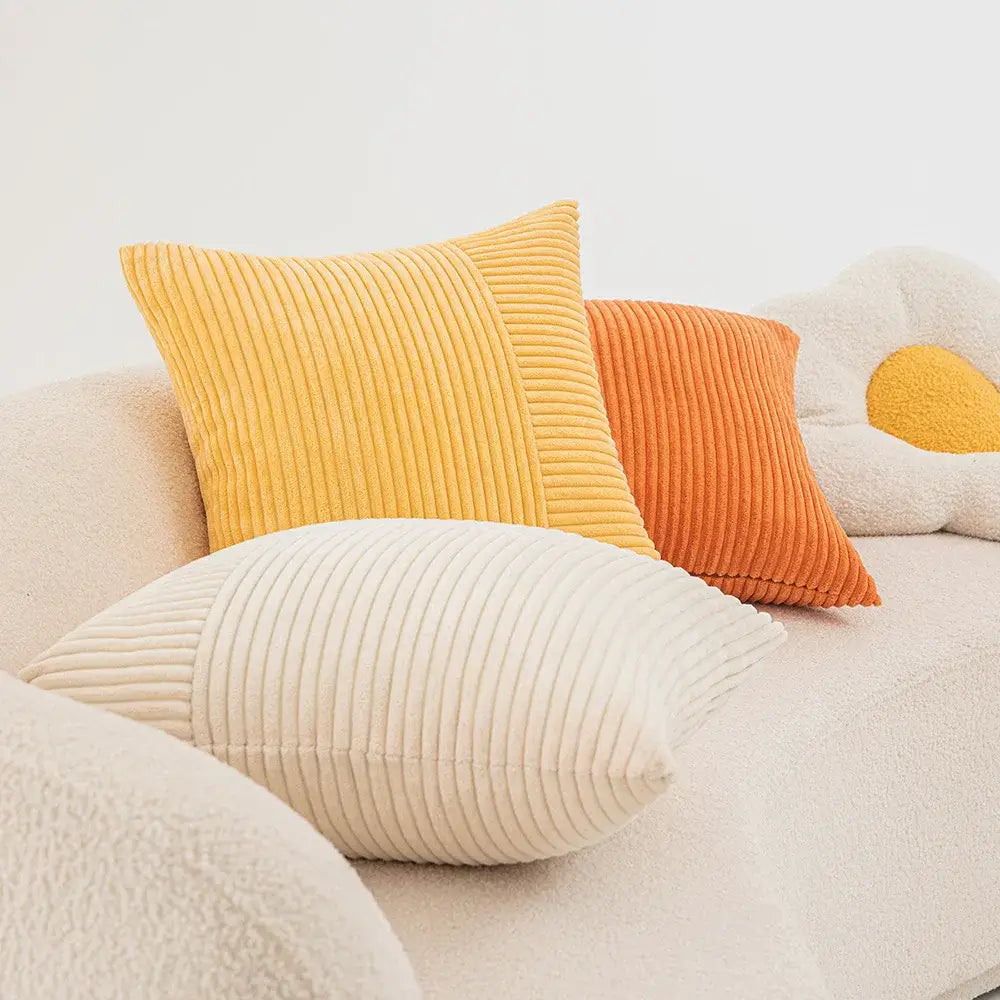 Mustard yellow decorbites corduroy striped pillow covers with vertical ribbed texture and subtle orange patchwork panel