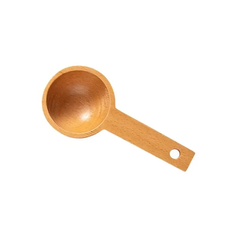 Light brown beech wood tablespoon coffee scoop with smooth rounded bowl and flat handle with hole for hanging