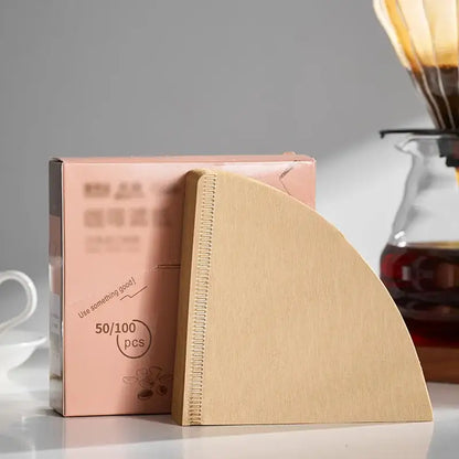 Natural brown cone coffee filter paper with stitched edge beside pink decorbites coffee filter packaging for barista use