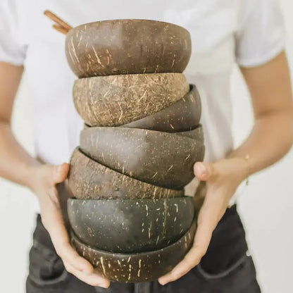 Stack of natural dark brown handcrafted decorbites coconut bowl set with textured surfaces for kitchen tableware