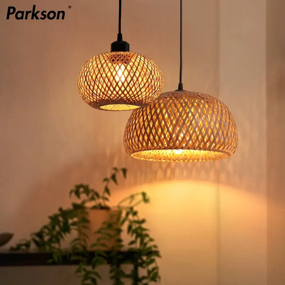 Two warm-toned natural lattice bamboo rattan pendant chandelier lights hang from black cords for dining room decorbites bamboo rattan lighting