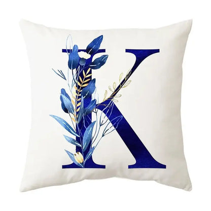 Cream-colored cushion with navy and gold alphabet flower letter k featuring decorbites blue alphabet botanical design