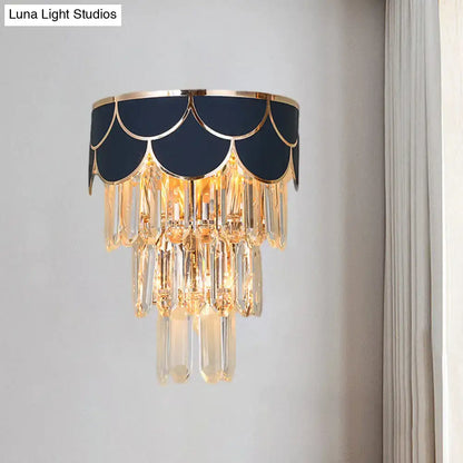 Elegant navy blue scalloped shade wall sconce with gold trim and cascading crystal droplets for living room lighting idea