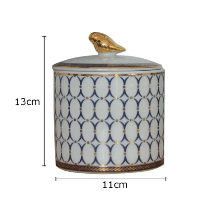 A white ceramic navy and white geometric storage jar with a gold plated bird lid for decorbites gold plated decor