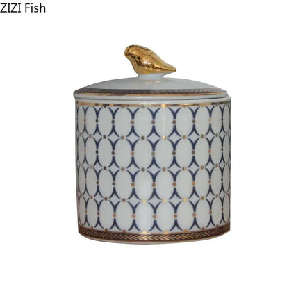 White porcelain storage jar with navy and white geometric pattern and gold plated bird decorbites gold plated topper