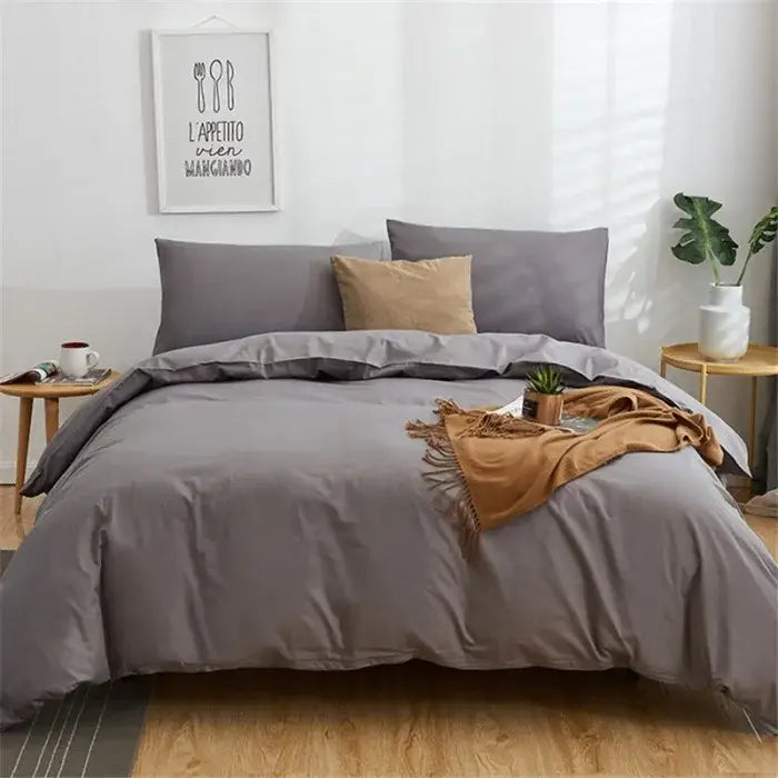 Gray solid color decorbites cotton 4pcs bedding set with matching pillowcases and tan throw blanket on bed
