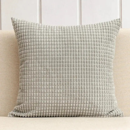 A square light gray waffle-textured throw pillow with plush fabric from the decorbites corduroy corn grain cushion cover set