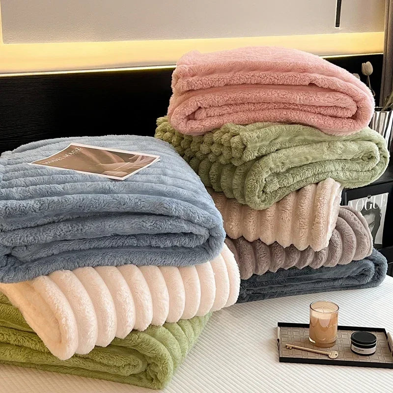 Stack of soft pastel ribbed fleece blankets in pink green blue and cream made from bamboo fiber for autumn warmth