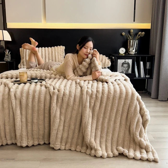 Cream-colored plush ribbed throw blanket with soft textured surface fluffy pom-pom trim made of bamboo fiber coral fleece