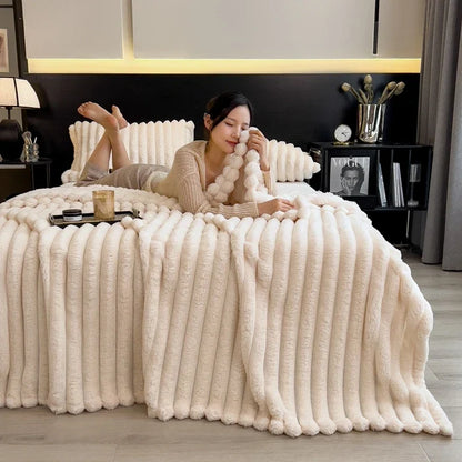 Cream-colored plush throw blanket with ribbed texture and chunky knit design made from soft bamboo fiber for cozy use
