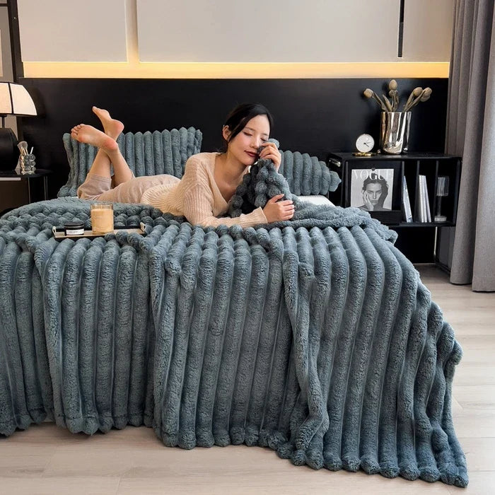Plush gray ribbed throw blanket made of soft coral fleece and bamboo fiber for warm autumn use on beds or sofas