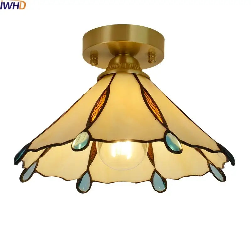 A brass-finished glass copper led ceiling light with amber and teal stained glass petals for bedroom use