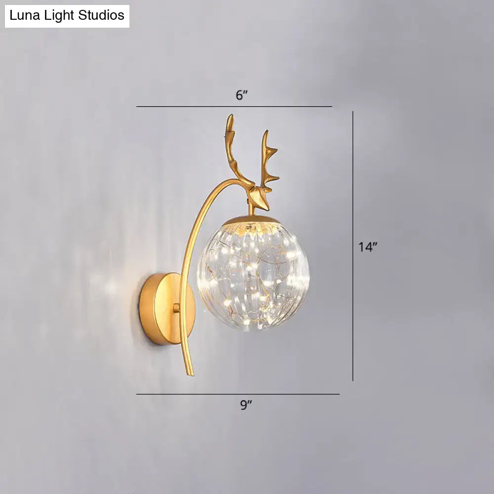 Gold-toned nordic ball wall mount deer-head sconce with clear crackled glass globe and warm led lights for bedroom use