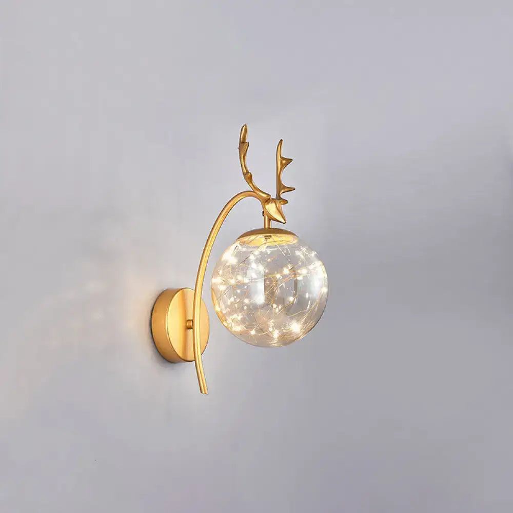 Gold-toned nordic ball wall mount black antler sconce with spherical glass globe and twinkling fairy lights for bedroom