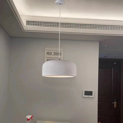 A modern white textured dome-shaped nordic led pendant lamp suspended by a thin cord for bar and restaurant lighting