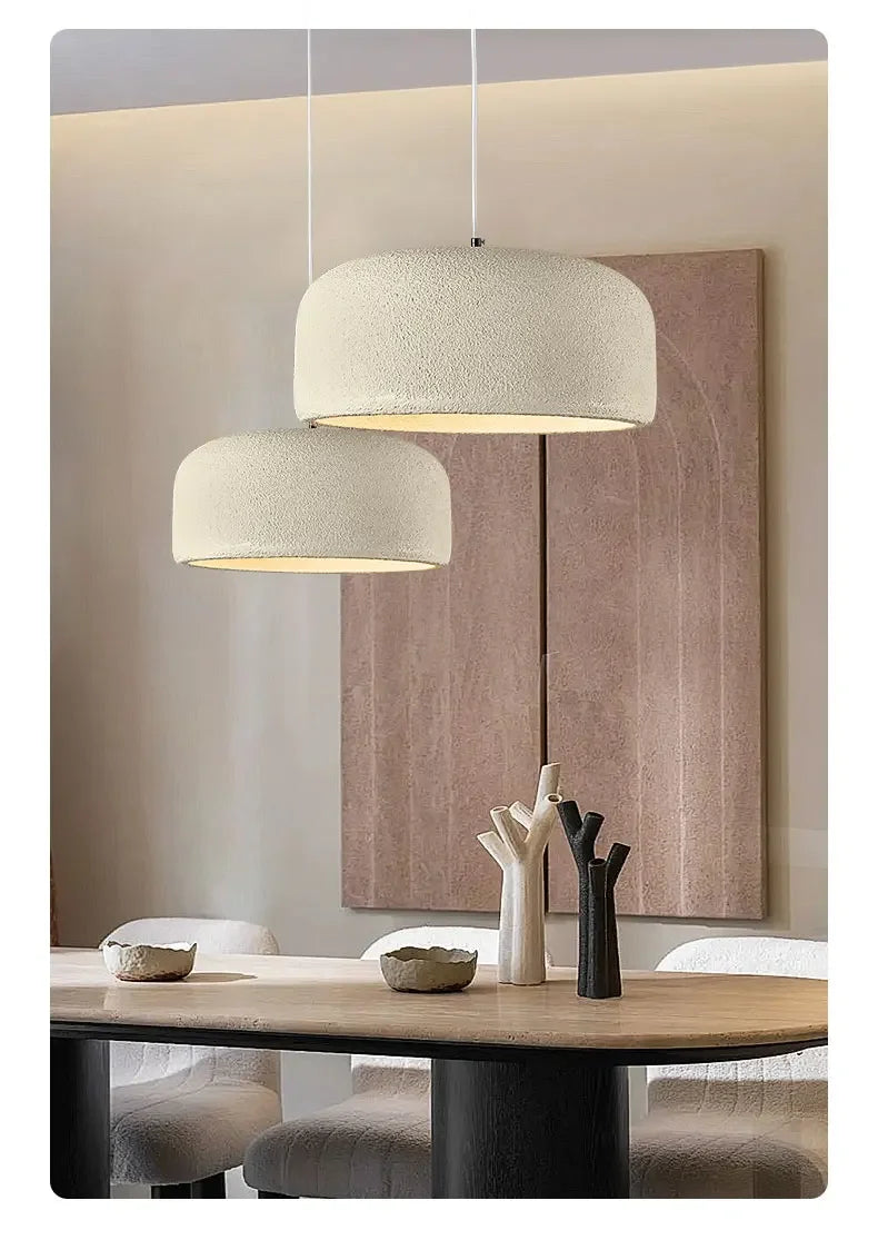 Cream-colored textured nordic led pendant lamps with minimalist design hanging above dining table for bar or restaurant use