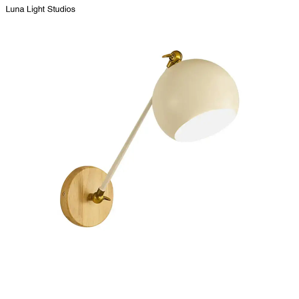 Cream-colored spherical wall light with brass-finished mounting plate and articulated arm for e26 e27 bulb socket use